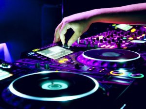 Dj mixes the track in the nightclub at a party